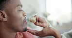 Hand, sushi and feeding a black man with a couple using chopsticks together in their home for romance. Food, face or smile and a happy young person eating a takeaway meal closeup with his girlfriend