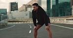 Breathing, road and fitness of man with rest from training, exercise and workout on city street. Marathon, runner and wellness of a tired athlete relax from running outdoor with sport and fatigue