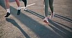 People, legs and running on road in fitness, outdoor exercise or cardio training on asphalt. Closeup of active or athlete group of runners feet in sprint, race or practice on street for lose weight