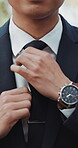 Hands, wedding and tie with a man getting reading for a marriage ceremony outdoor at an event closeup. Fashion, watch and vertical with a groom dressing in a smart or formal suit to get married