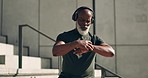 Runner, checking time and exercise in city with heart rate for wellness, health and thinking. Mature black man, workout and  fitness with smart watch, headphones and training with sports headphones