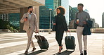 Business people, team walking and travel with suitcase in city for corporate, job opportunity and networking. Professional woman and men talking at outdoor hotel or on the way to airport with luggage