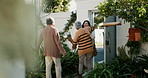Happy family, open door and hug with flowers outdoor of home in backyard with daughter and parents with love. Reunion, welcome and woman with mom and dad, travel and surprise for holiday with embrace