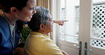 Senior, man in wheelchair and nurse pointing to outdoor view for healthcare support with caregiver in nursing home. Old person, medical and professional for elderly care in bedroom of house or clinic