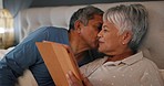 Love, kiss and senior couple in a bed with tablet for social media, streaming or ebook at home. Happy, relax and retired man with old woman in a bedroom for digital, search or chat communication