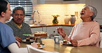 Cake, nurse and assisted living with an old couple laughing together in the kitchen of their home. Senior man, woman and caregiver storytelling a funny joke in a house for happy humor in retirement