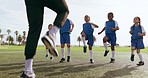 Children, leg warm up and sport on soccer field with coach for training and school fitness. Youth, kids and workout for competition in uniform with girl and athlete group with students and exercise