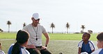 Coach, talking and children on field for soccer prepare for game, match and practice outdoors. Sports, teamwork and young kids huddle for training formation, exercise and planning for tournament