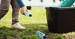 People, hands and recycling plastic bottle for community service, pollution or saving environment in nature. Closeup of person cleaning waste, recycle or dirt in bin on natural grass of outdoor park