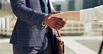 Business people, shaking hands and travel in city for b2b partnership, outdoor deal and meeting or success. Corporate or professional clients handshake for consulting and introduction in urban town