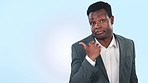 Secret, business man and pointing in studio to mockup space isolated on a blue background. Portrait, doubt and African person shrug at advertising gossip, confidential marketing of privacy or silence