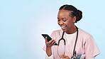 Doctor, woman and phone with healthcare communication, funny chat and telehealth service or social media in studio. Professional african nurse laughing on mobile for medical meme on a blue background