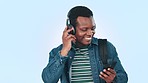 Dance, headphones and black man in studio with phone for streaming song, radio and audio. Travel, student and person listening to music, happy and excited for university or college on blue background