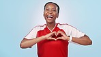 Black woman, soccer player and face with heart hand sign and happy from sport love in studio. Fitness, workout and training with romance and emoji gesture with smile from athlete and blue background