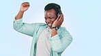 Music, headphones and black man in studio dance for streaming song, radio and audio. Happy, freedom and person listening to track, excited and move with energy, fun and happiness on blue background