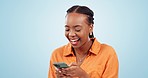 Woman, laugh and typing with smartphone in studio, scroll social media and reading funny notification on blue background. Happy african model download app, mobile games and search meme on cellphone