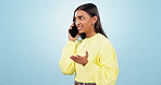Woman, argument and angry or conflict on phone call, frustrated and annoyed in studio by blue background. Indian person, frustrated and angry on smartphone, communication and discussion on issues