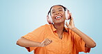 Dance, happy woman and music headphones in studio for celebration of freedom, disco party or excited audio on blue background. African model listening to multimedia, hearing sound or energy for radio