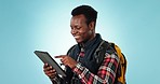 Travel, tablet and black man in studio with digital app for holiday and hiking in studio. Vacation, adventure and African male person with direction information with backpack and blue background