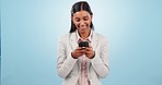 Phone, happy and businesswoman in studio typing a message on social media or mobile app. Smile, technology and professional Indian female lawyer networking on the internet isolated by blue background