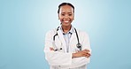 Face, doctor and black woman with arms crossed, career and healthcare on a blue studio background. Portrait, African person and model with a smile, medical professional and surgeon with happiness