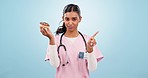 Woman nurse with donut and no gesture for nutrition, wellness or health diet in studio. Upset, medical and portrait of Indian female doctor nutritionist with sweet dessert isolated by blue background