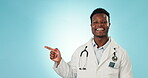 Black man, doctor pointing at healthcare tips or information with presentation in mockup space on blue background. Portrait, medical news or announcement with health advertising in studio and launch