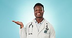 Happy black man, doctor and palm in advertising, marketing or product against a blue studio background. Portrait of African male person, medical or healthcare worker with hand out on mockup space