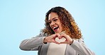 Happy woman, heart and hands in portrait, support and charity with emoji isolated on blue background. Help, care and love sign with health, wellness and donation, kindness and feedback in a studio