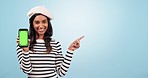 Pointing, green screen and woman with phone in studio with mockup space for marketing. Tracking markers, mock up and portrait of Indian female model with cellphone with chroma key by blue background.