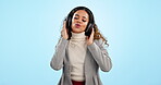 Music, dance and sing with a woman on a blue background in studio for freedom, energy or wellness. Radio, streaming and headphones with a happy young gen z person moving to audio sound to relax