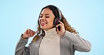 Music, dance and smile with a woman singing on a blue background in studio for freedom, energy or wellness. Radio, streaming and headphones with a happy young person moving to audio sound to relax