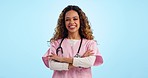 Nurse in portrait, woman has arms crossed and healthcare, smile with confidence with pride on blue background. Medical professional, trust and help with caregiver and stethoscope for health in studio