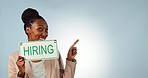 Happy black woman, hiring sign and pointing on mockup for business opportunity against a studio background. Portrait of African female person or employee smile with billboard for recruiting or career