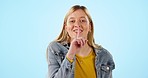 Happy, woman and emoji to whisper secret, gossip or confidential information on blue background in studio. Smile, wink and girl with finger on lips or body language for privacy, shush and quiet voice