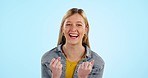 Face, excited and woman with celebration, feedback and success on a blue studio background. Portrait, happy person or model cheering, achievement and review with good news, announcement and promotion