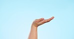 Hand holding, zoom and person with product placement in studio with platform, offer or space on blue background. Palm, closeup and model show service, deal or opportunity, presentation or sale promo