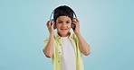 Kid, dancing and listening to music in studio with smile on blue background in mockup for fun, promotion and summer. Youth, boy or person with headphones for app, streaming or game on social media
