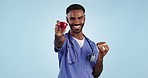 Food choice, health and a doctor or man with an apple or donut on a blue background. Happy, thinking and face portrait of a male nurse with decision for nutrition, fruit or unhealthy snack for diet