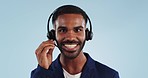 Telemarketing, headset and face of black man in studio talking with smile, help and advice. Phone call, discussion and happy crm consultant, customer support or callcenter agent on blue background.