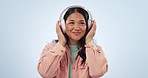 Studio music, happy dance and Asian woman listening, streaming and enjoy radio podcast, kpop or relax media song. Audio headphones, wellness sound and Japanese dancer smile on blue background