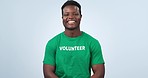 Volunteer, black man smile and face with NGO,social responsibility logo and charity tshirt in studio. Nonprofit, portrait and African male person happy from activist platform with blue background
