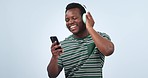 Music, phone and happy black man dancing, listening and streaming radio podcast, studio song or media app playlist. Headphones, cellphone and African dancer energy, sound and audio on blue background