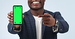 Happy man, phone and pointing to green screen in advertising or marketing against a studio background. Closeup of businessman showing mobile smartphone app, display or mockup with tracking markers