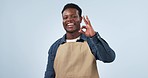 Waiter man, ok sign and smile in studio, face and excited for good service review by blue background. African server, small business owner or barista with icon, emoji and happy with feedback for cafe