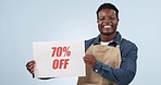 Happy black man, billboard and sign on discount price or promotion against a studio background. Portrait of African male person or employee smile with poster for deal, store promo or advertising sale