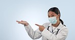 Asian woman, doctor and pointing to palm with mask in advertising against a studio background. Portrait of female person, medical or healthcare surgeon showing product or information on mockup space