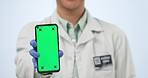 Scientist, hands and phone with green screen in advertising or marketing against a studio background. Closeup of healthcare, science or medical surgeon showing mobile smartphone app display or mockup