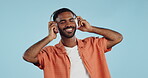 Man, student and headphones for listening to music, dance and mental health for education and wellness in studio. Young african person for audio streaming service, techno or rave on a blue background