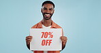 Discount, sign and promotion, man and portrait, show information and smile isolated on blue background. Poster, billboard or banner with sale news, announcement on board with advertising in studio